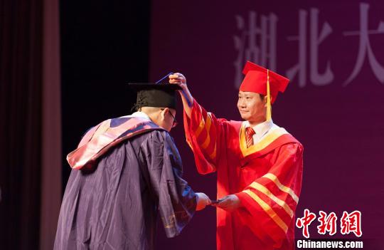 图为，湖北大学校长赵凌云为毕业生拨穗正冠 向正鹏 摄